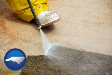 pressure washing a concrete surface - with North Carolina icon