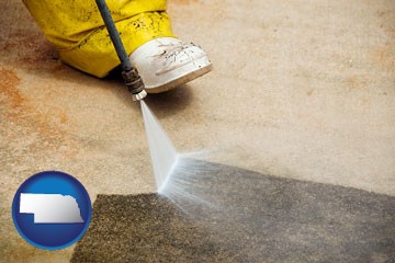 pressure washing a concrete surface - with Nebraska icon