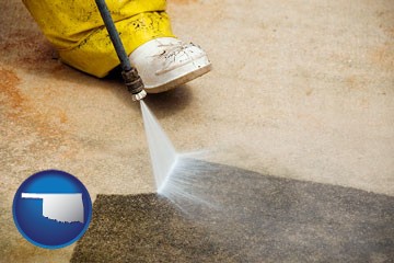 pressure washing a concrete surface - with Oklahoma icon